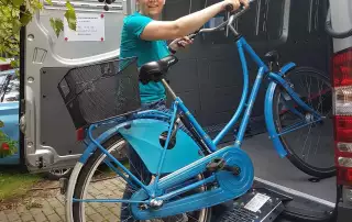 Michaela schiebt Fahrrad in die mobile Werkstatt
