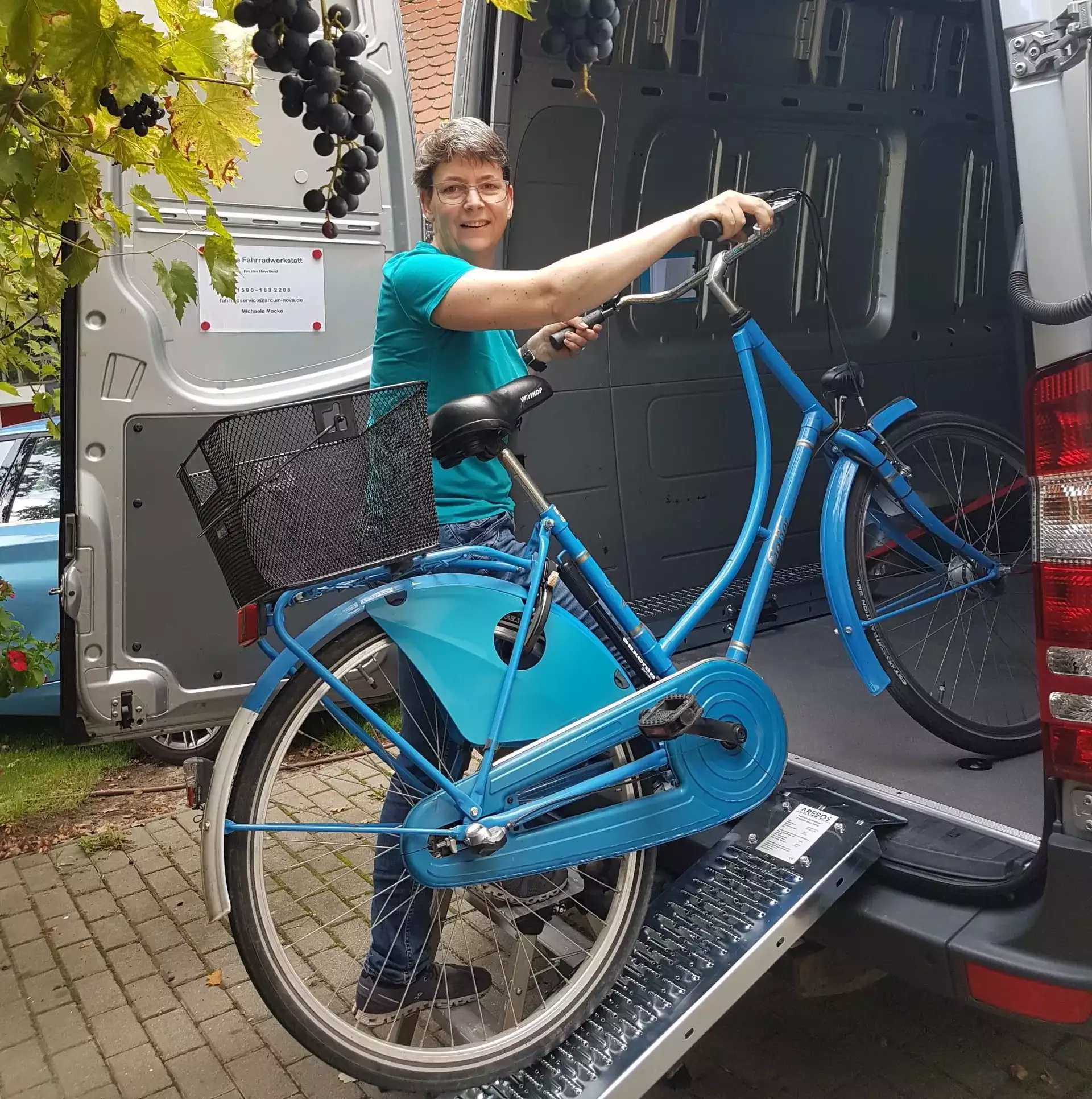 Michaela schiebt Fahrrad in die mobile Werkstatt